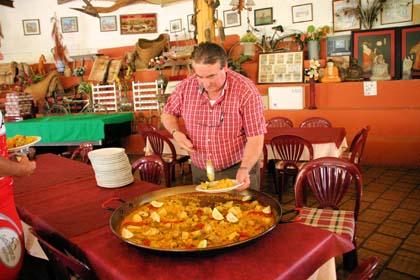 Paco verteilt fachgerecht die Paella in der Piscina von Parcent